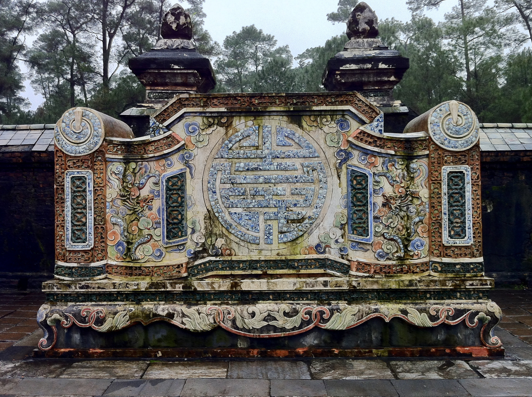 Monument with sign for longevity with lotus flowers on top at Vietnamese Buddhist temple/tomb