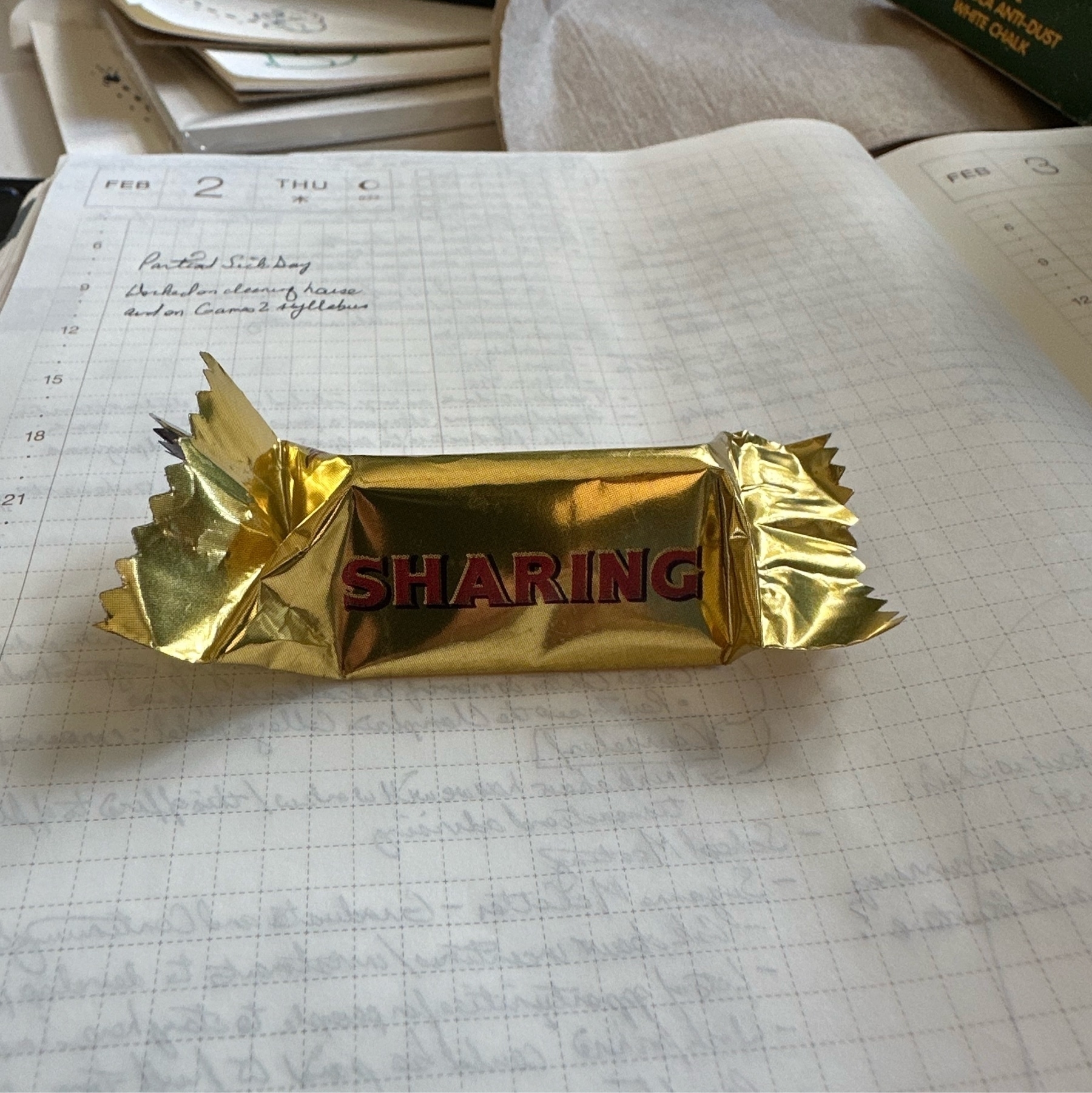 Photograph of a Toblerone chocolate bar in its wrapping on top of an open notebook