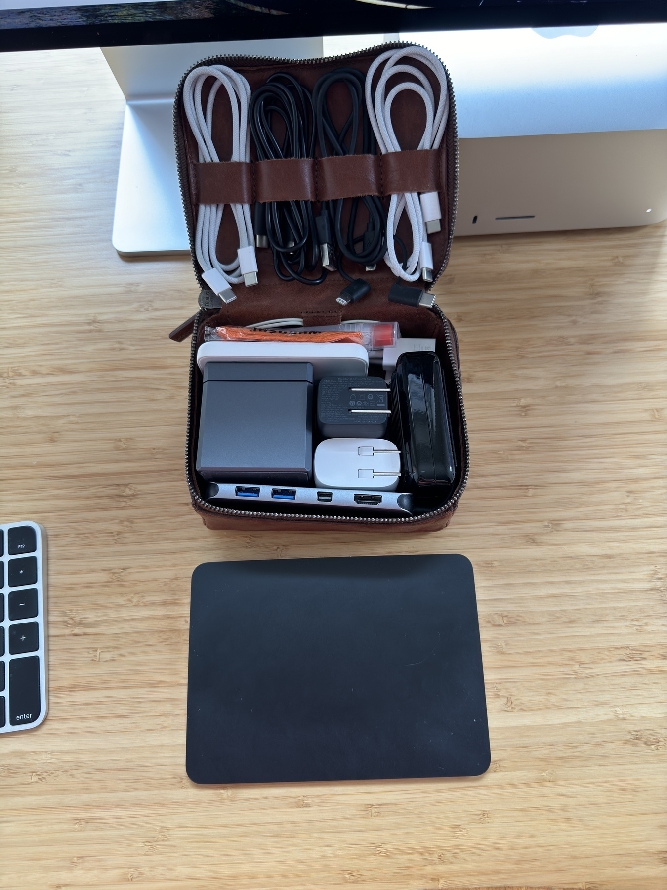 Tech travel bag including an Anker Cube and various cables and chargers
