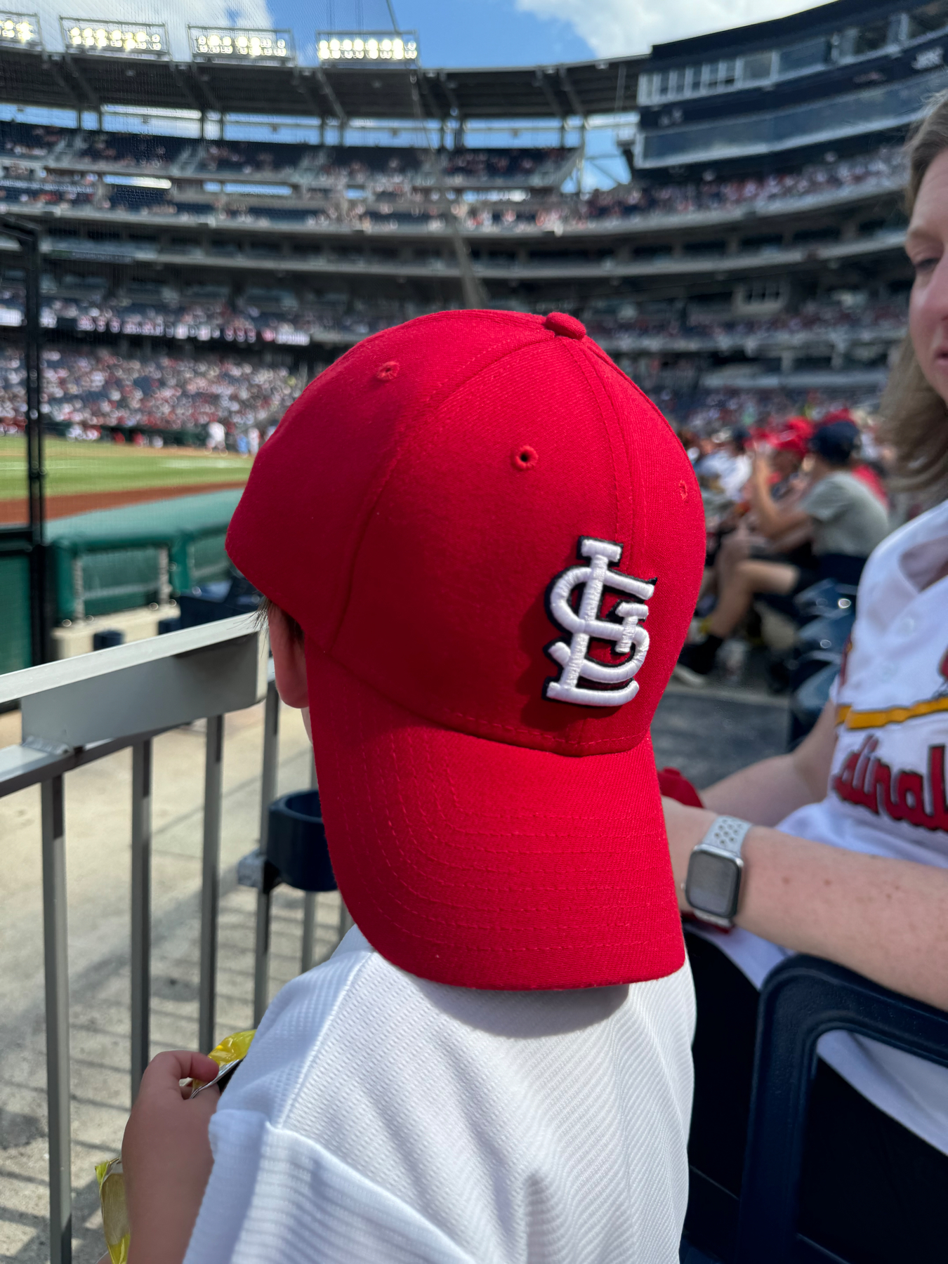 Jude with a Cardinals cap turned backwards looking towards home plate 