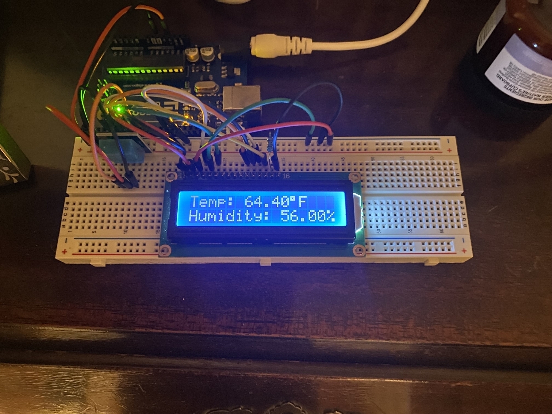 An Arduino project board with a breadboard set up with a temperature and humidity sensor and an LCD display the current values.