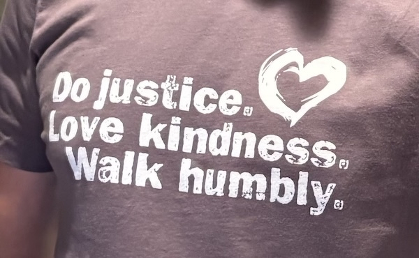 A purple T-shirt says to do justice, love kindness, and walk humbly