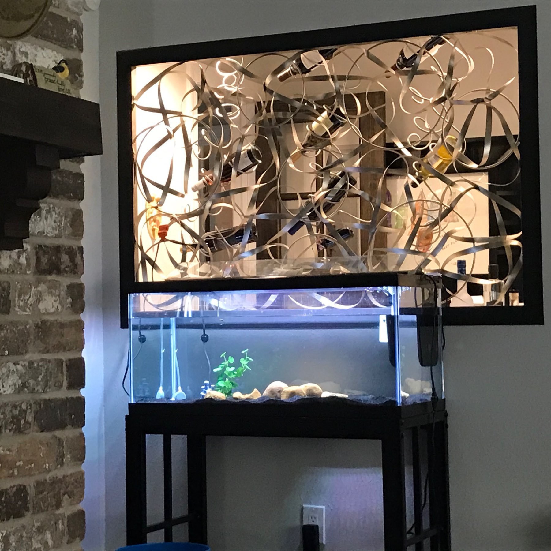 aquarium fish tank in front of a metal art piece