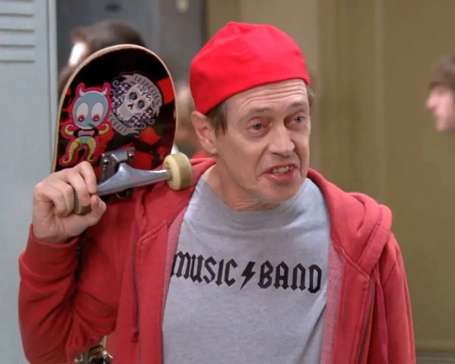 Steve Buscemi as the Fellow Kids guy, holding a skateboard and wearing a backwards ball cap with his MUSIC BAND t-shirt