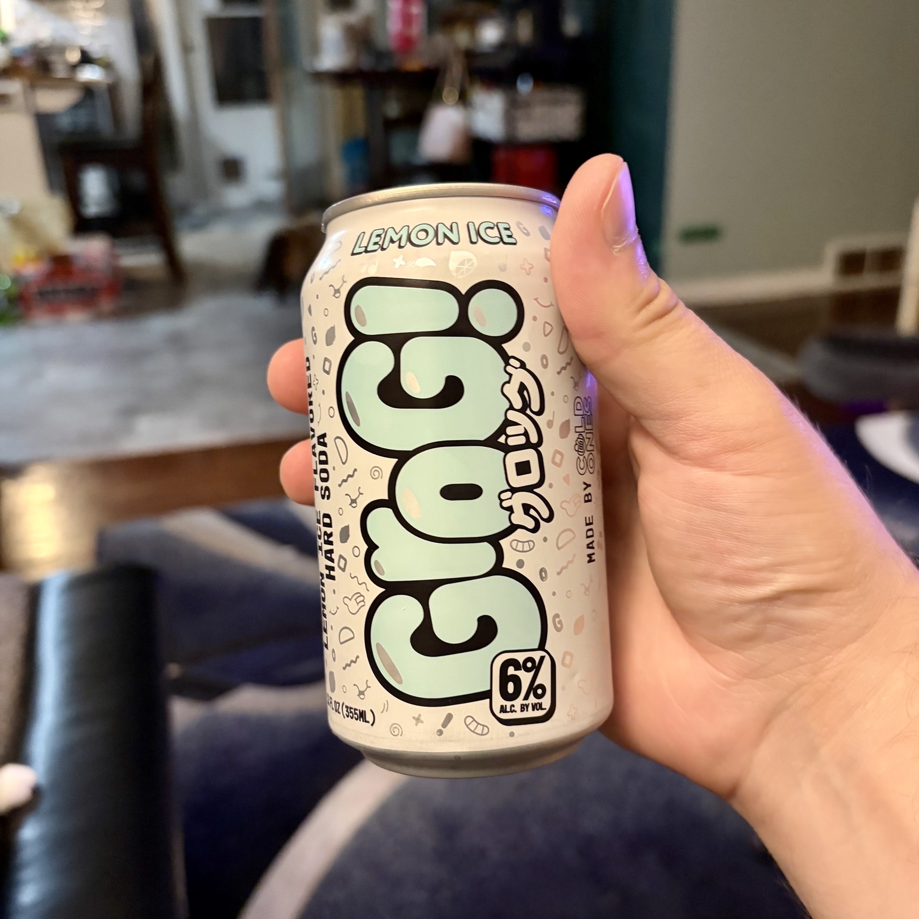 A hand is holding a can of Glog! Lemon Ice flavored drink with 6% alcohol content.