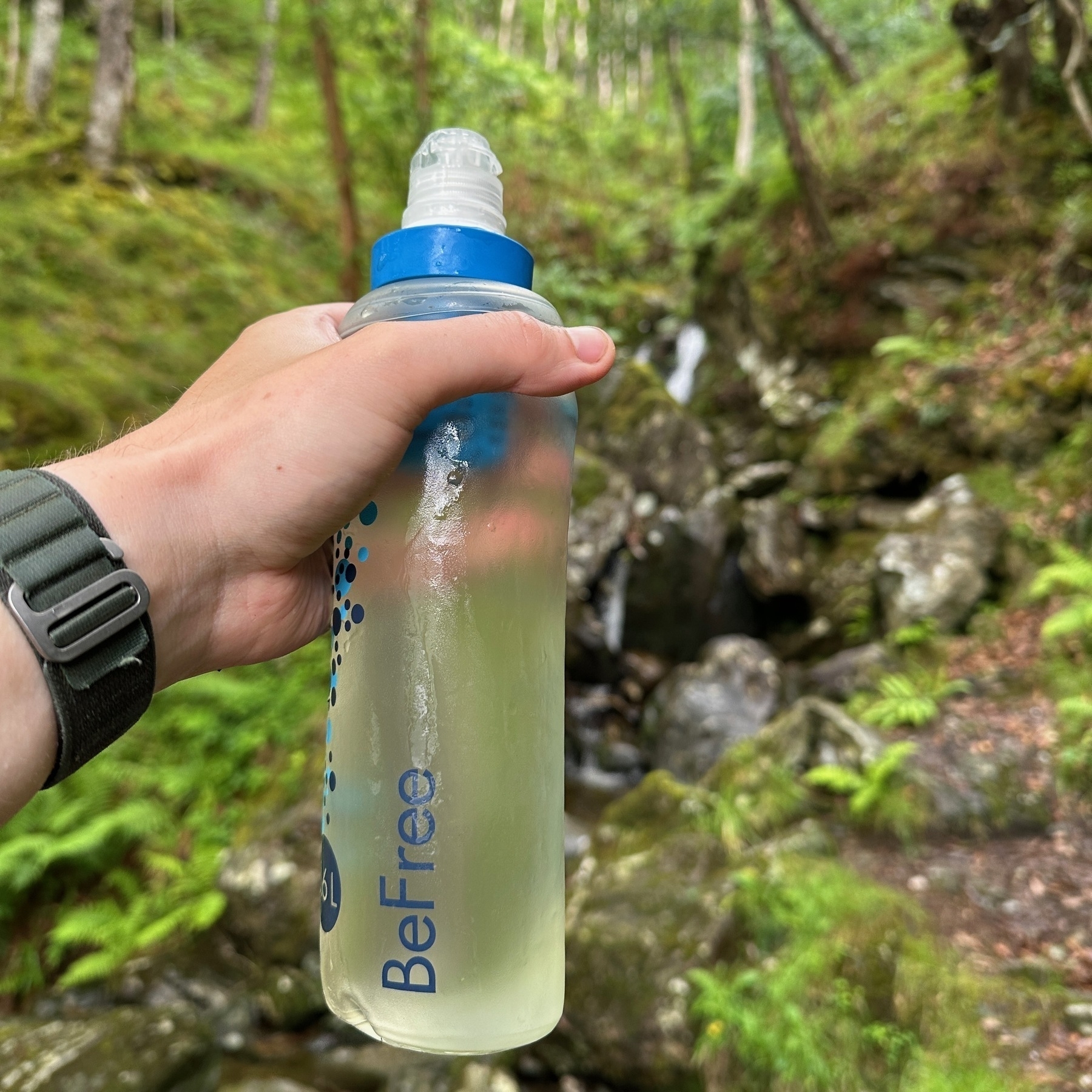 A water filter containing clear looking water from a waterfall next to Loch Lomond