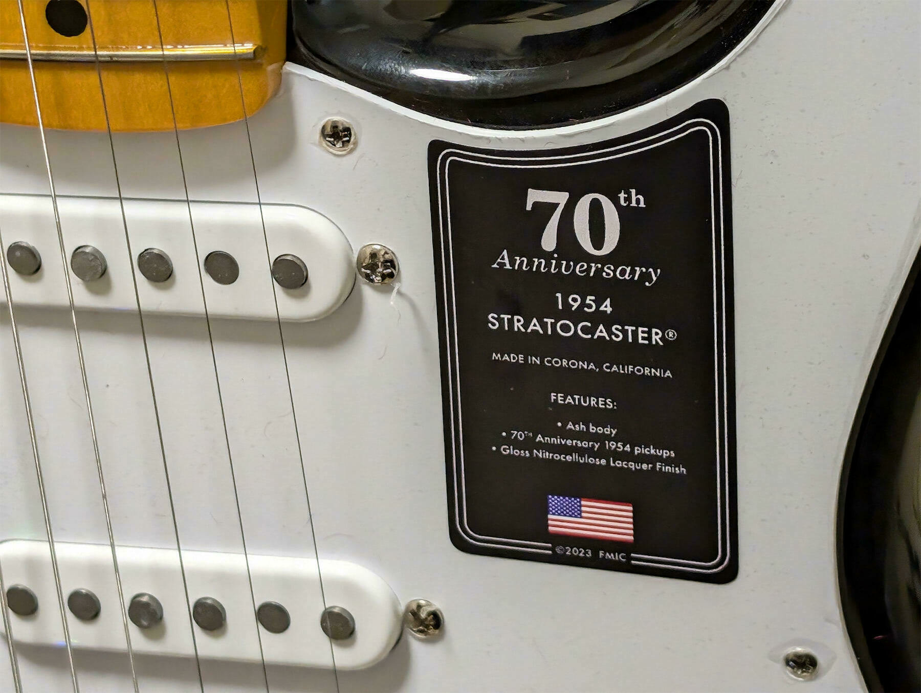 A close-up view of a 70th Anniversary 1954 Stratocaster guitar showing its label.