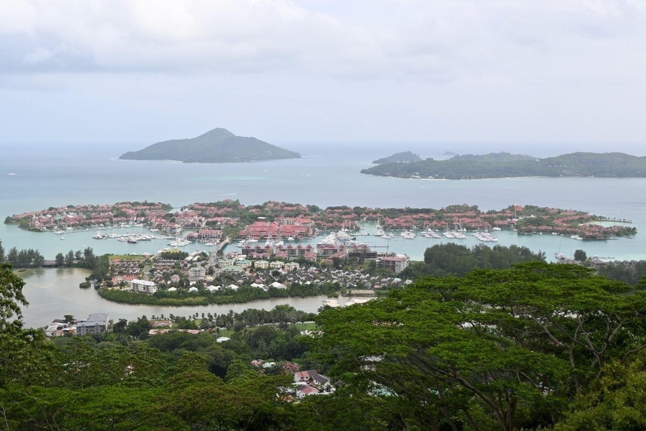 Auto-generated description: A scenic view of a coastal landscape with islands, water, and lush greenery under a cloudy sky.