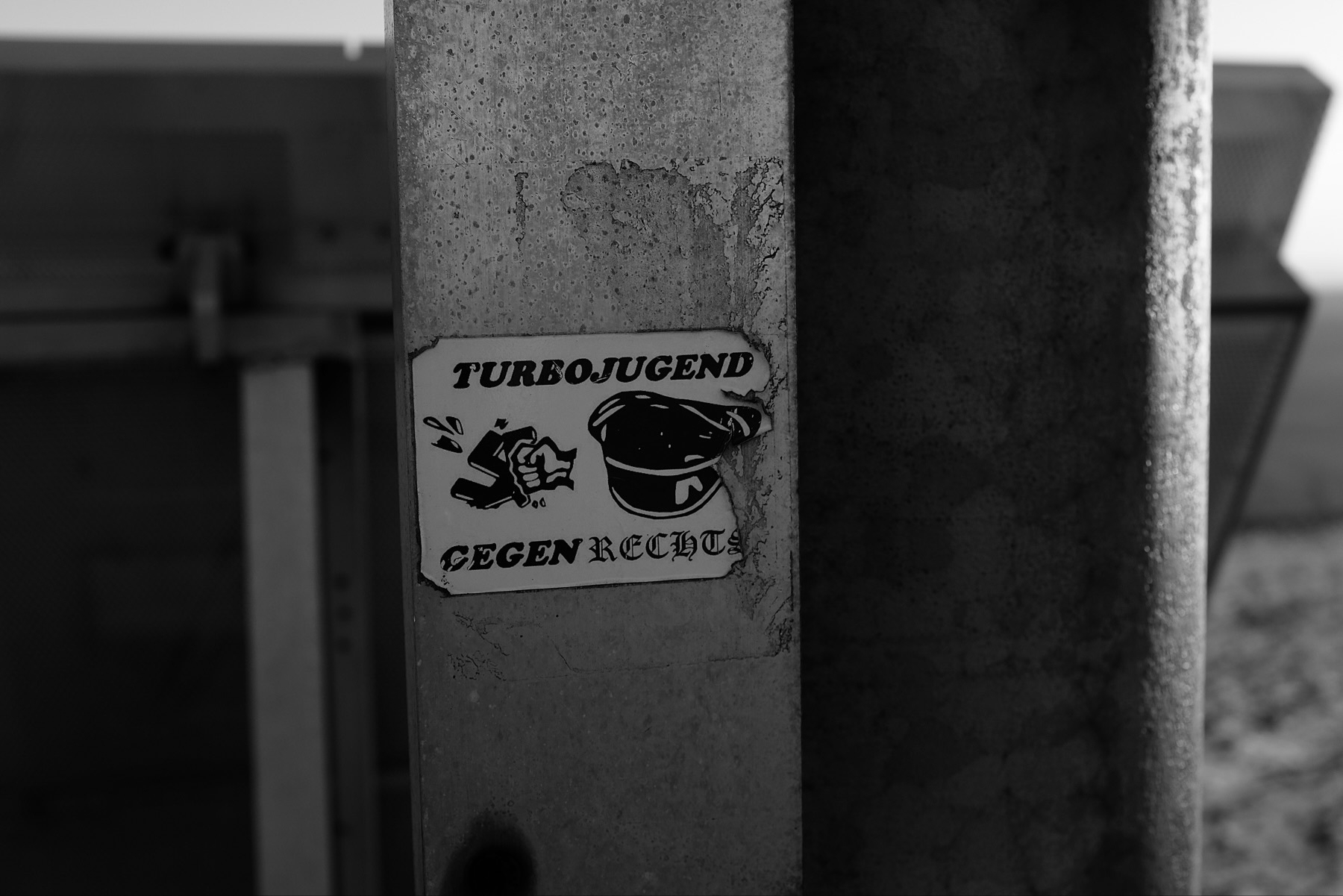 A black and white sticker on a metal pole features the text Turbojugend gegen rechte