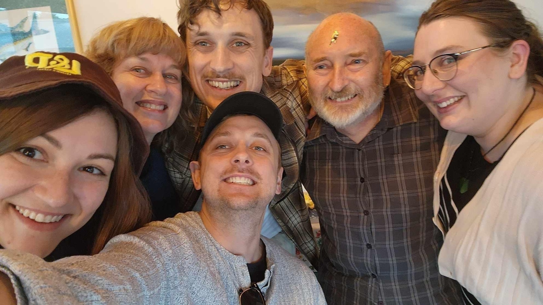 Auto-generated description: A group of six people is smiling for a selfie together.