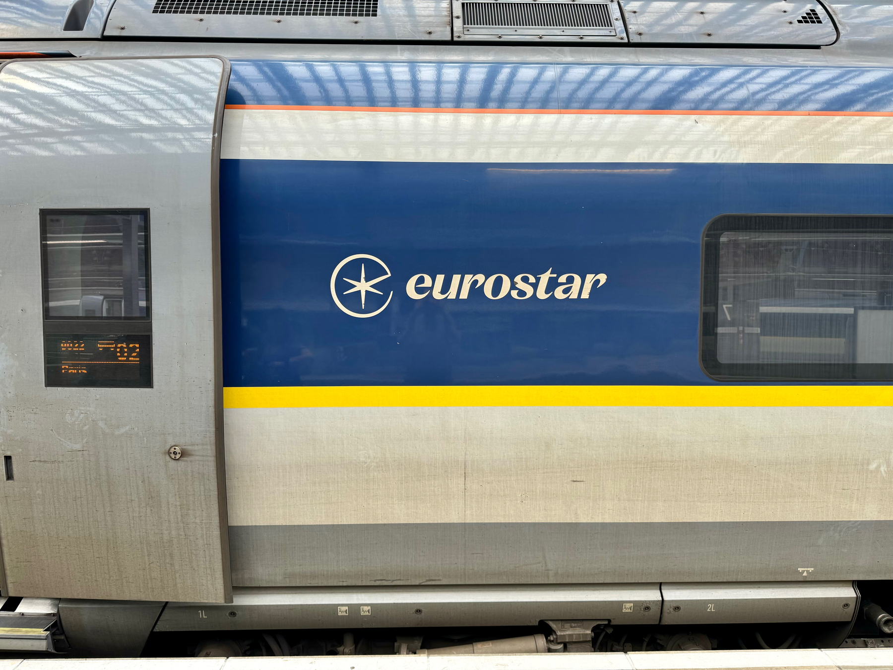Eurostar train at a station with a destination sign showing “Paris.
