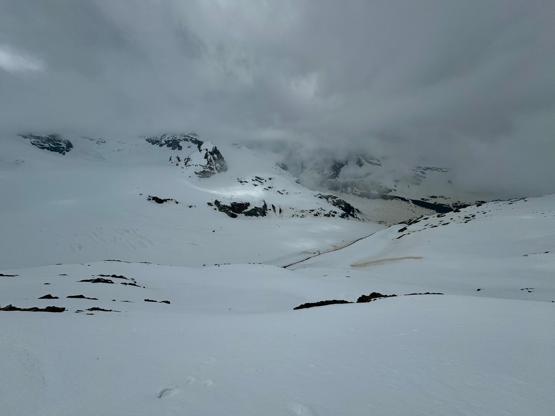 Snow-covered mountain landscape with overcast skies.