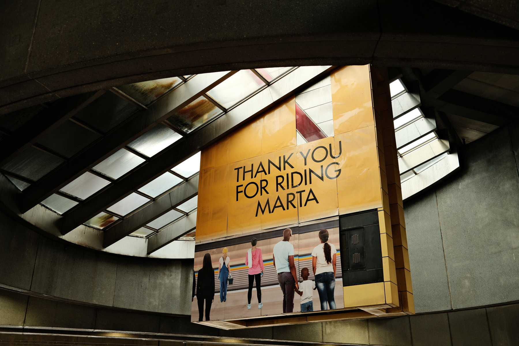 Auto-generated description: A large sign with the text THANK YOU FOR RIDING MARTA is displayed in a transportation station.