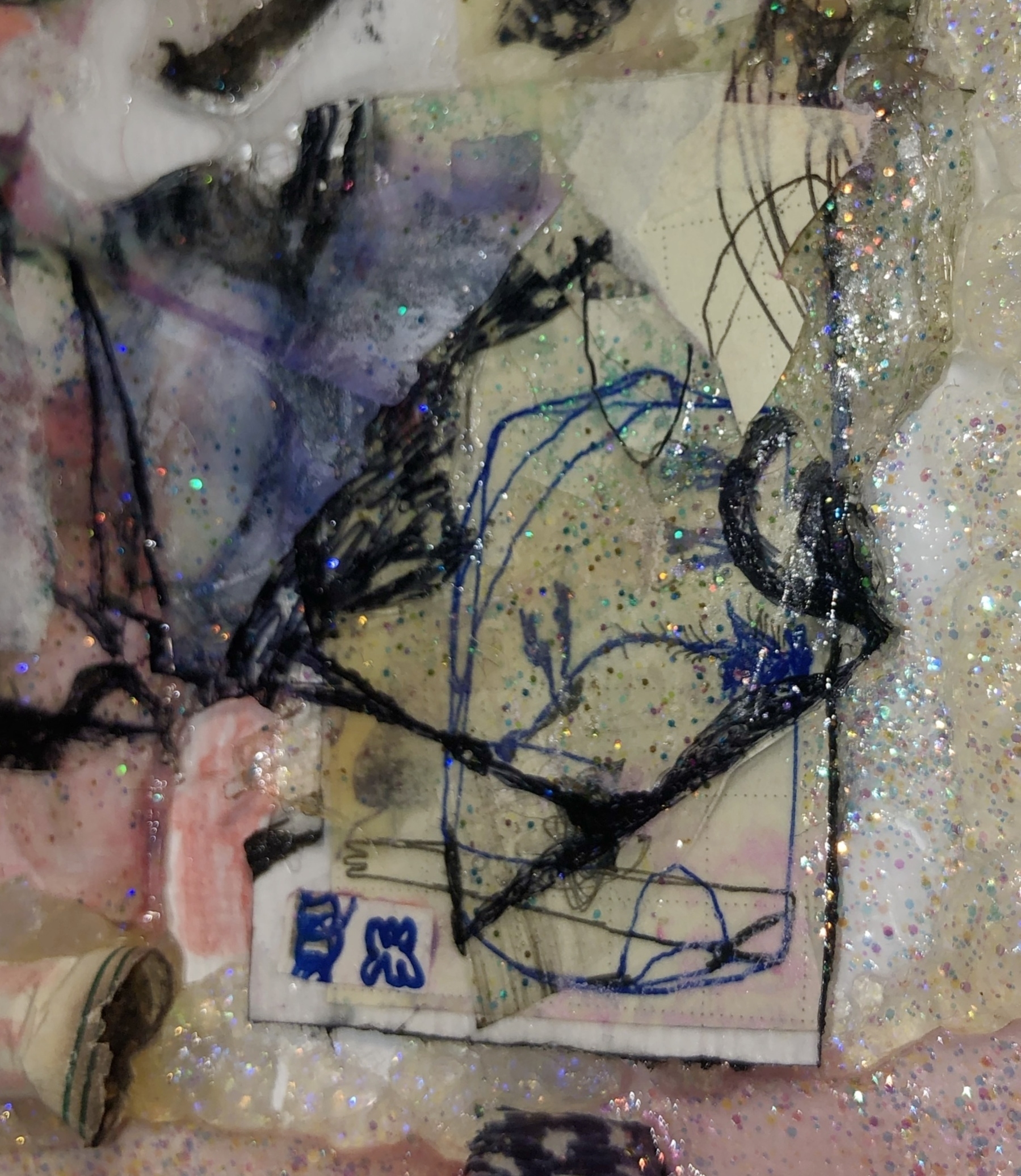 Auto-generated description: A collage featuring abstract shapes and designs, incorporating glitter, fabric, and scribbled blue lines on a textured surface.