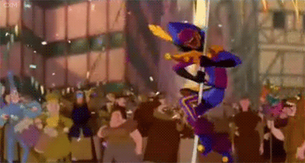 Clopin from the Disney film “The Hunchback of Notre Dame” swings around a pole as confetti falls.