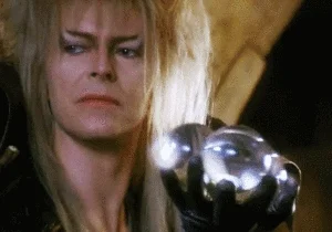 The Goblin King from the movie Labyrinth contact juggles multiple clear balls.
