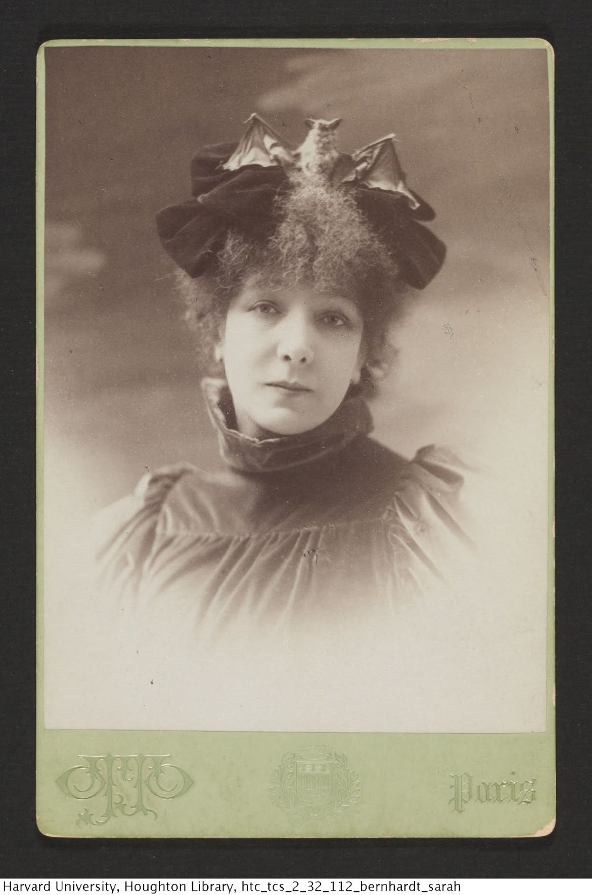 Actress Sarah Bernhardt wears a hat with a taxidermied bat standing in the center of it.