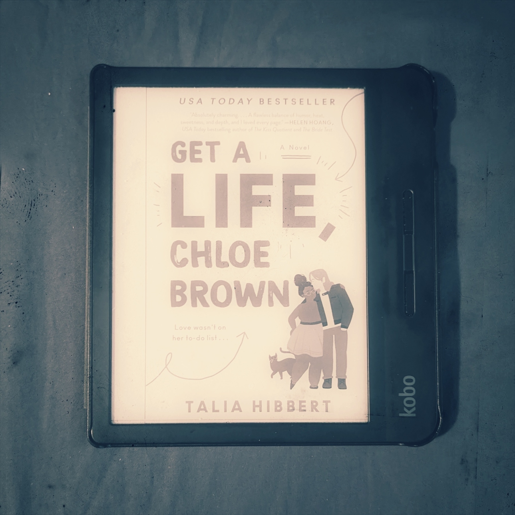 An e-reader displaying the cover of a romance novel by Talia Hibbert, featuring an illustration of two people and a cat. The title is 'Get A Life, Chloe Brown' and it is a USA Today Bestseller.