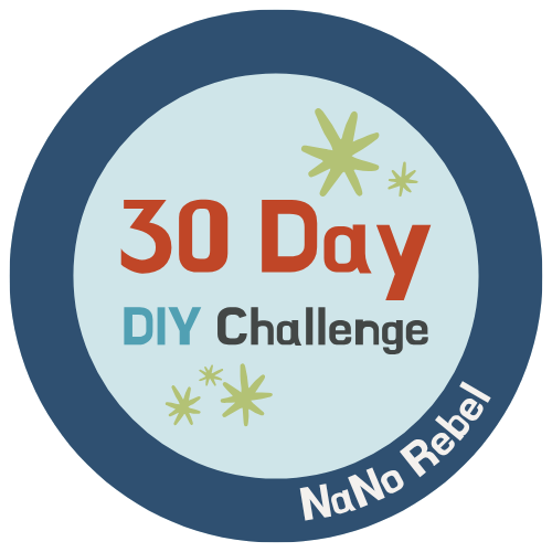 Auto-generated description: A circular badge featuring the text 30 Day DIY Challenge with decorative stars and NaNo Rebel written along the bottom edge.