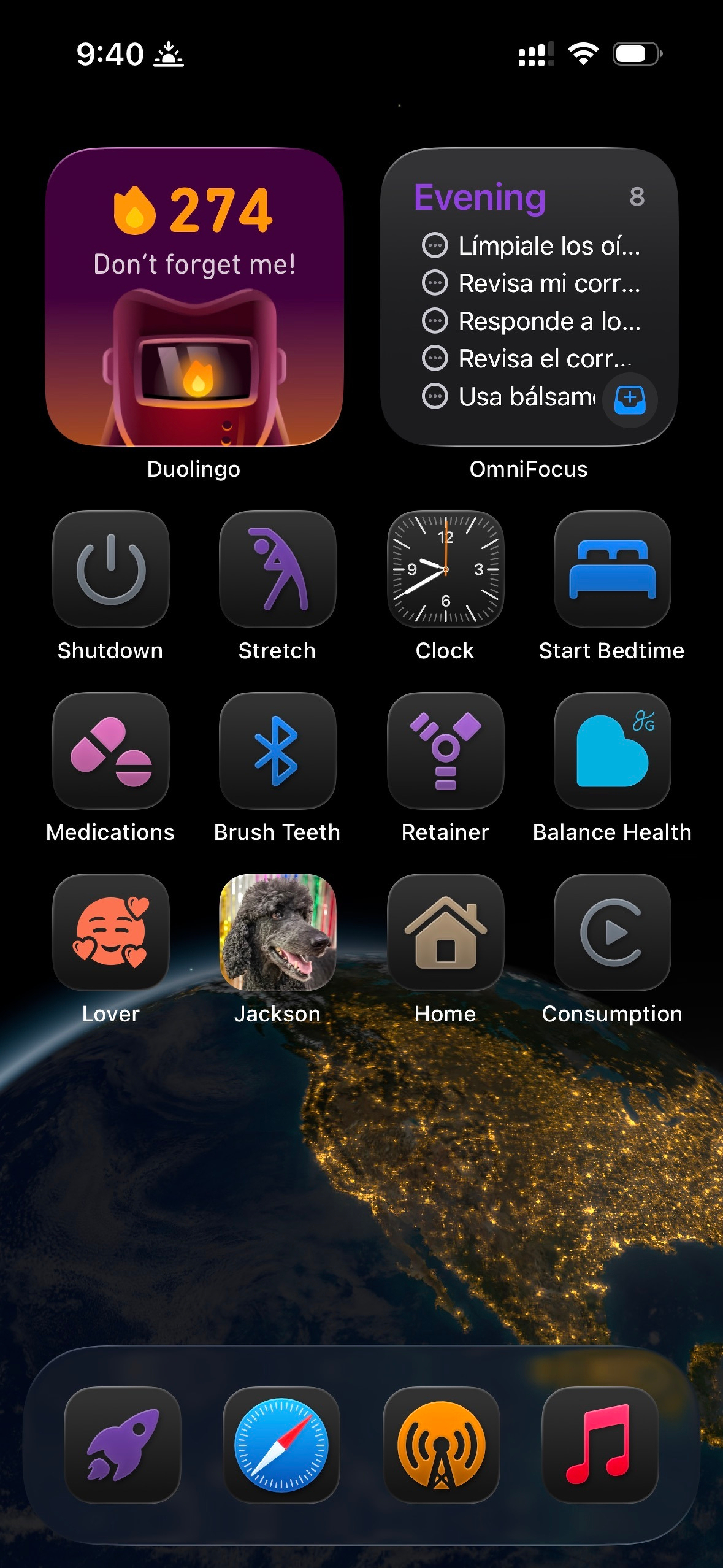 An iOS home screen (in Small icon mode with labels under the icons) showing a nighttime view of the globe the background. The first row has Duolingo and OmniFocus widgets. The second row has Shutdown, Stretch, Clock, and Start Bedtime shortcuts. The third row has Medications, Brush Teeth, Retainer, and Balance Health icons. The fourth row has Lover, Jackson, Home, and Consumption shortcuts. The dock at the bottom has a personal shortcuts launcher, Safari, Overcast, and Music.