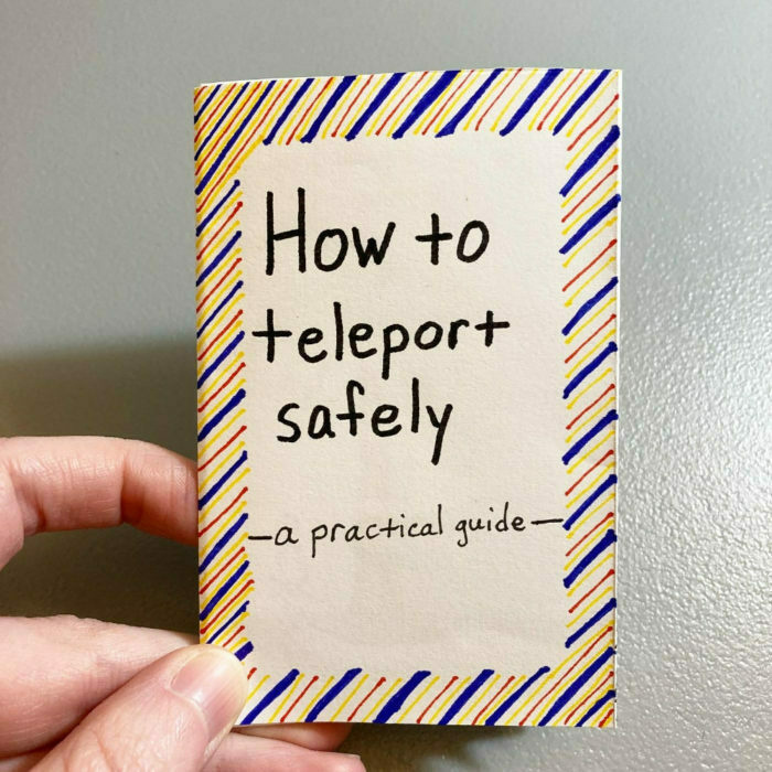 A hand holds a small booklet titled How to teleport safely — a practical guide, featuring a striped border.