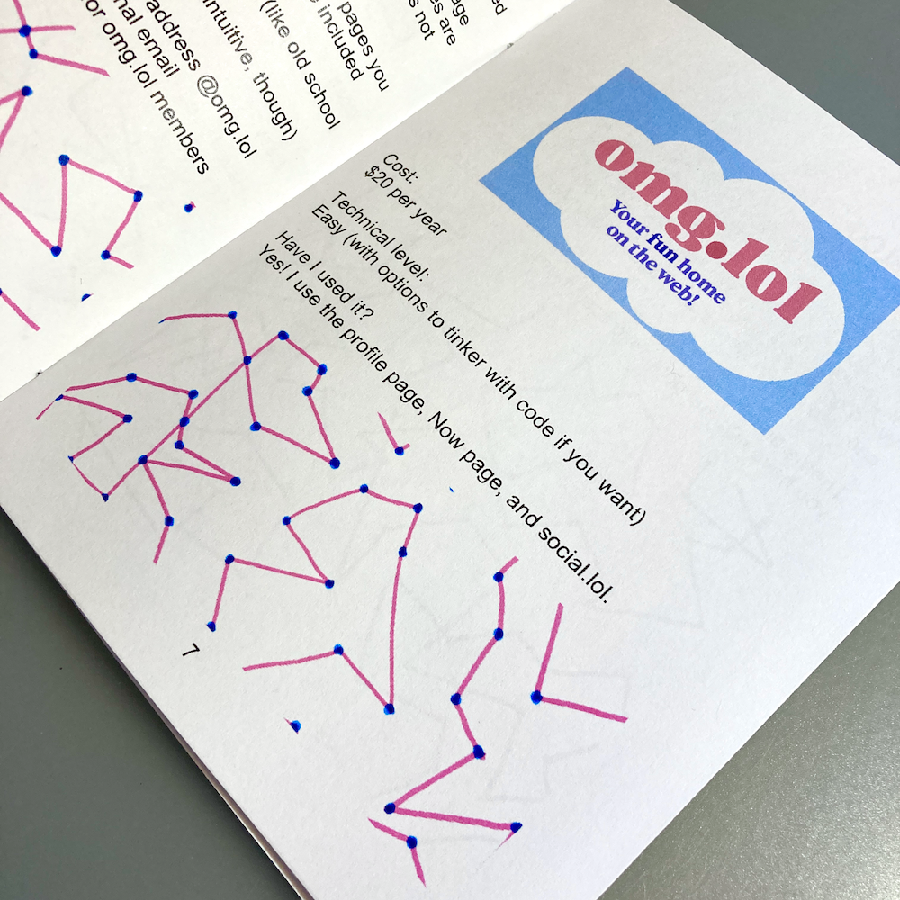 A zine is open to a page featuring a promotional graphic for omg.lol alongside connect-the-dots doodles.