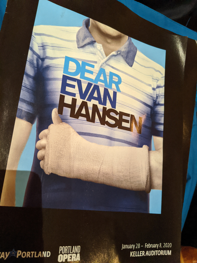 A person in a blue striped shirt with a cast on their arm is featured on a poster for Dear Evan Hansen at Keller Auditorium.