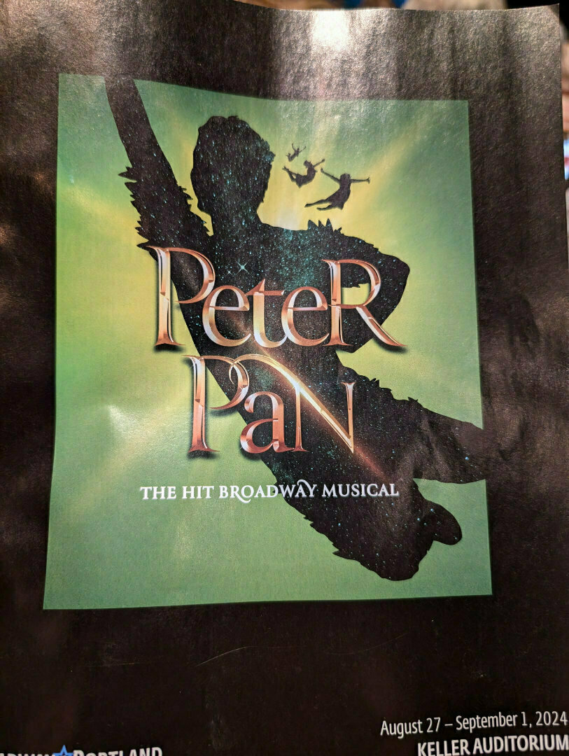 A poster for the Broadway musical Peter Pan features a silhouette of Peter Pan in flight against a green background with text indicating show dates and location.
