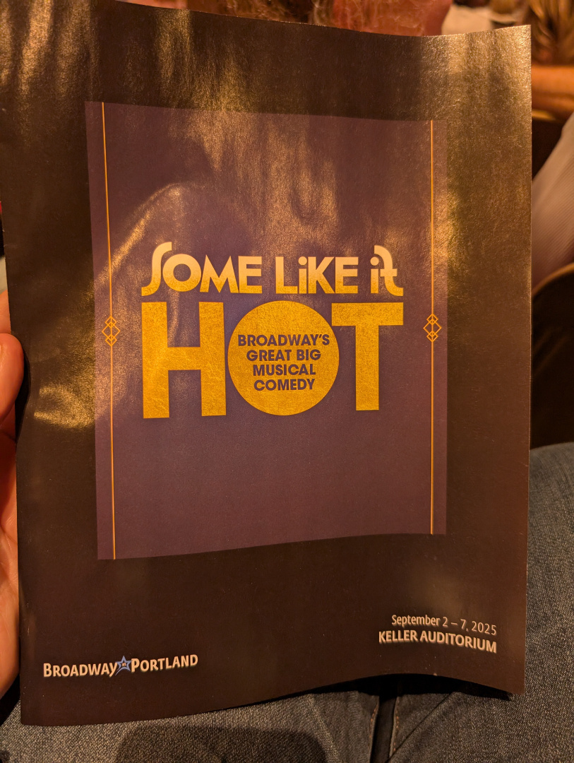 A hand holds a program for the musical comedy Some Like It Hot at Keller Auditorium, dated September 2-7, 2025.