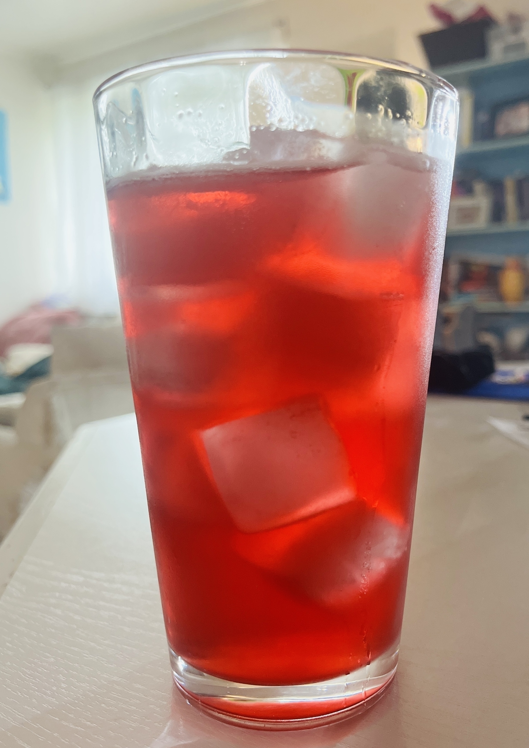 glass of sparkling red beverage over ice