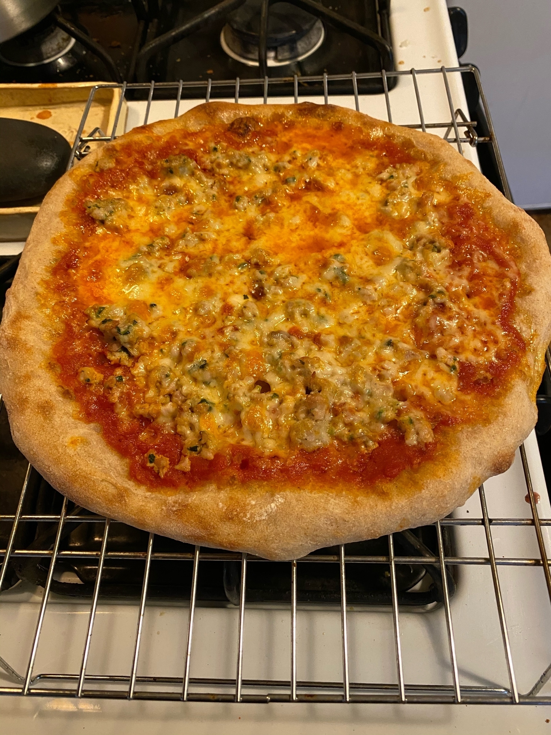Yet another small pizza on a cooling rack.