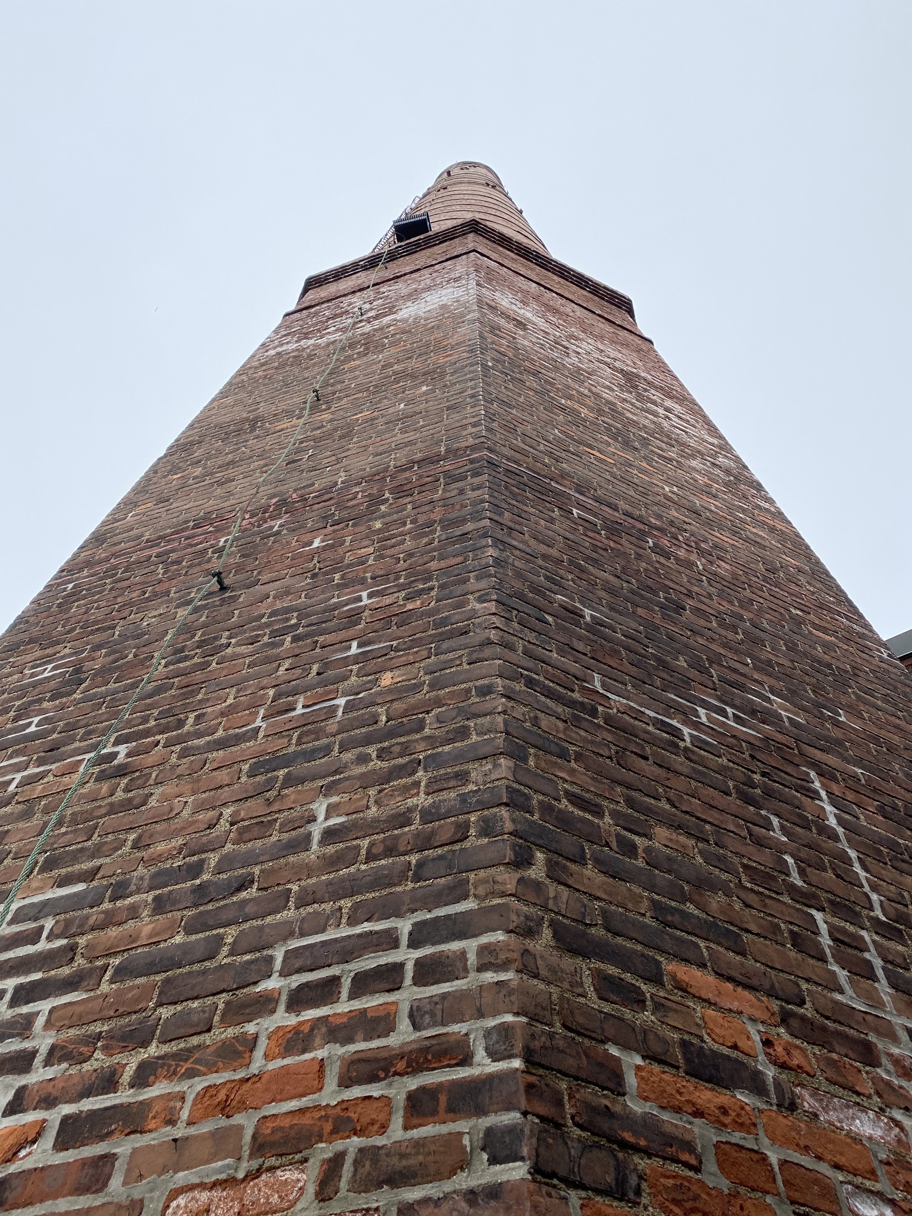 View of a tall brick chimney from immediately below.