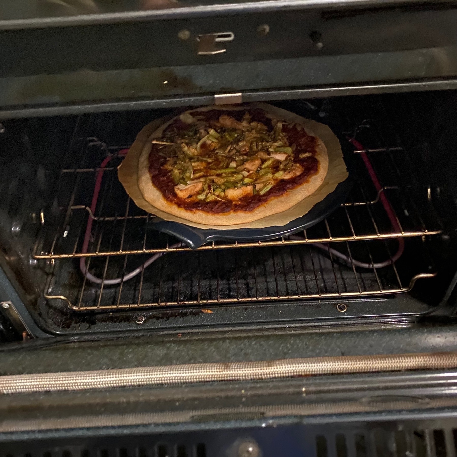 Pizza on a rack in an oven.