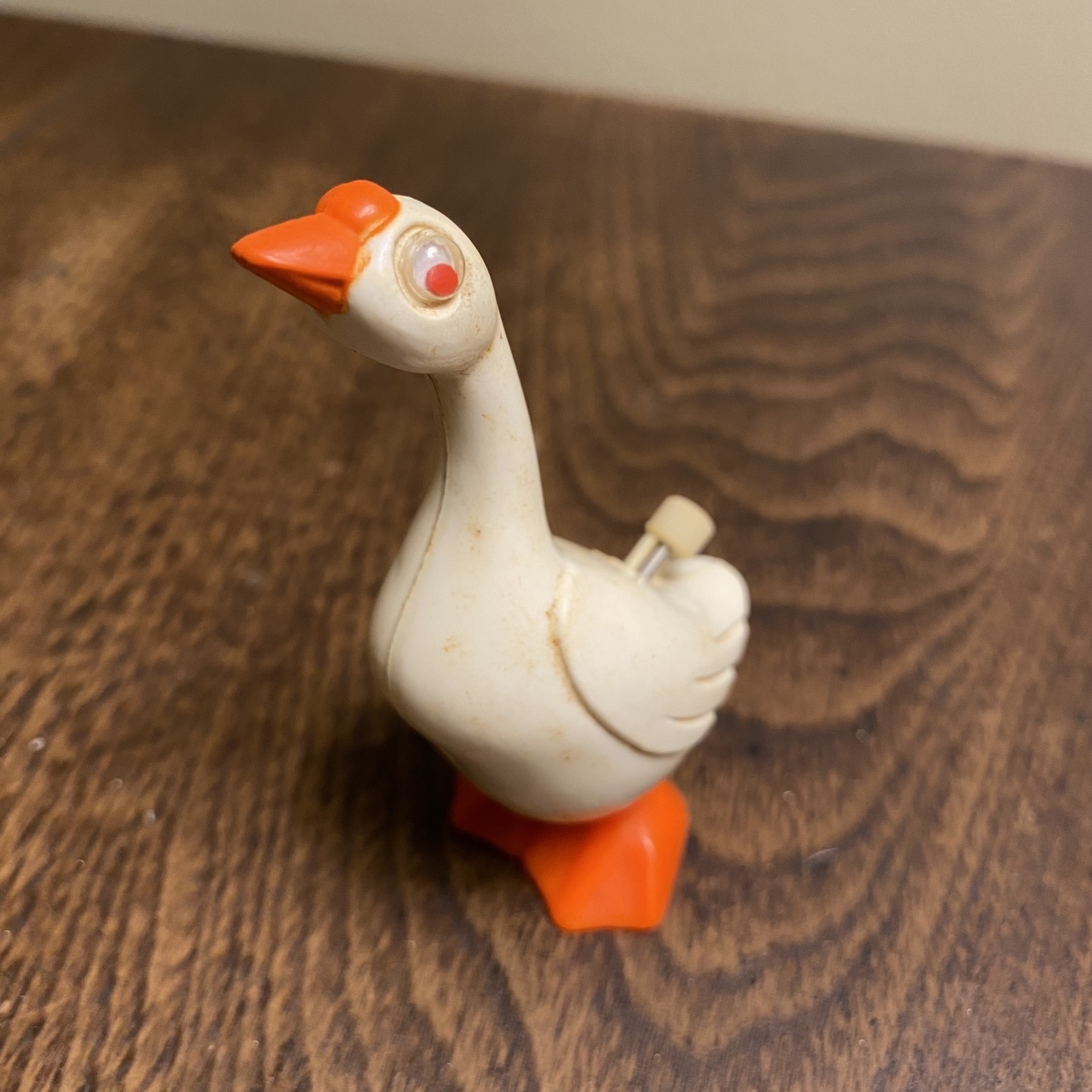 Close up of a small white goose wind-up toy.