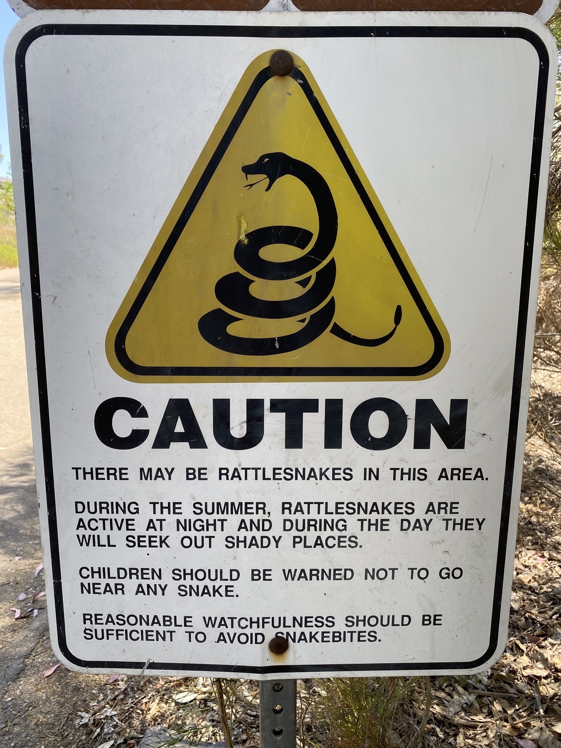 Caution sign warning that there may be rattlesnakes in the area.