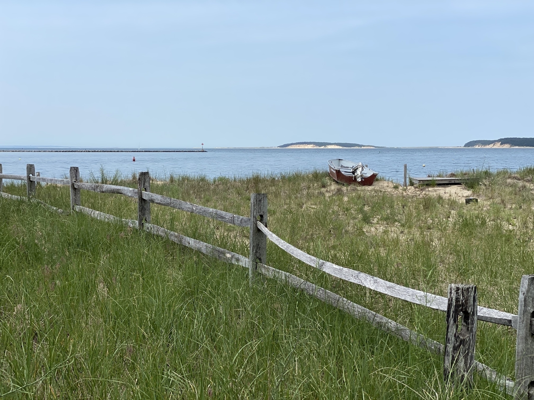 View of Wellfleet Bay with a wooden fence in the foreground.