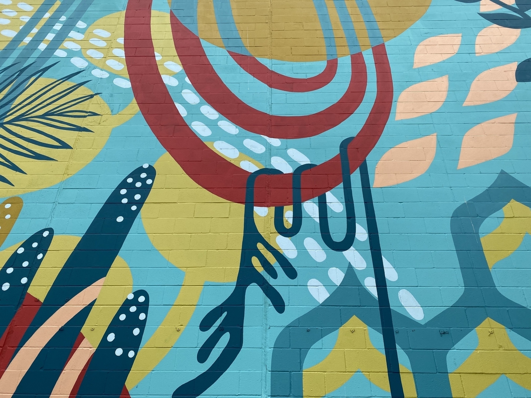 Mural on the side of a building of abstract shapes and colors.