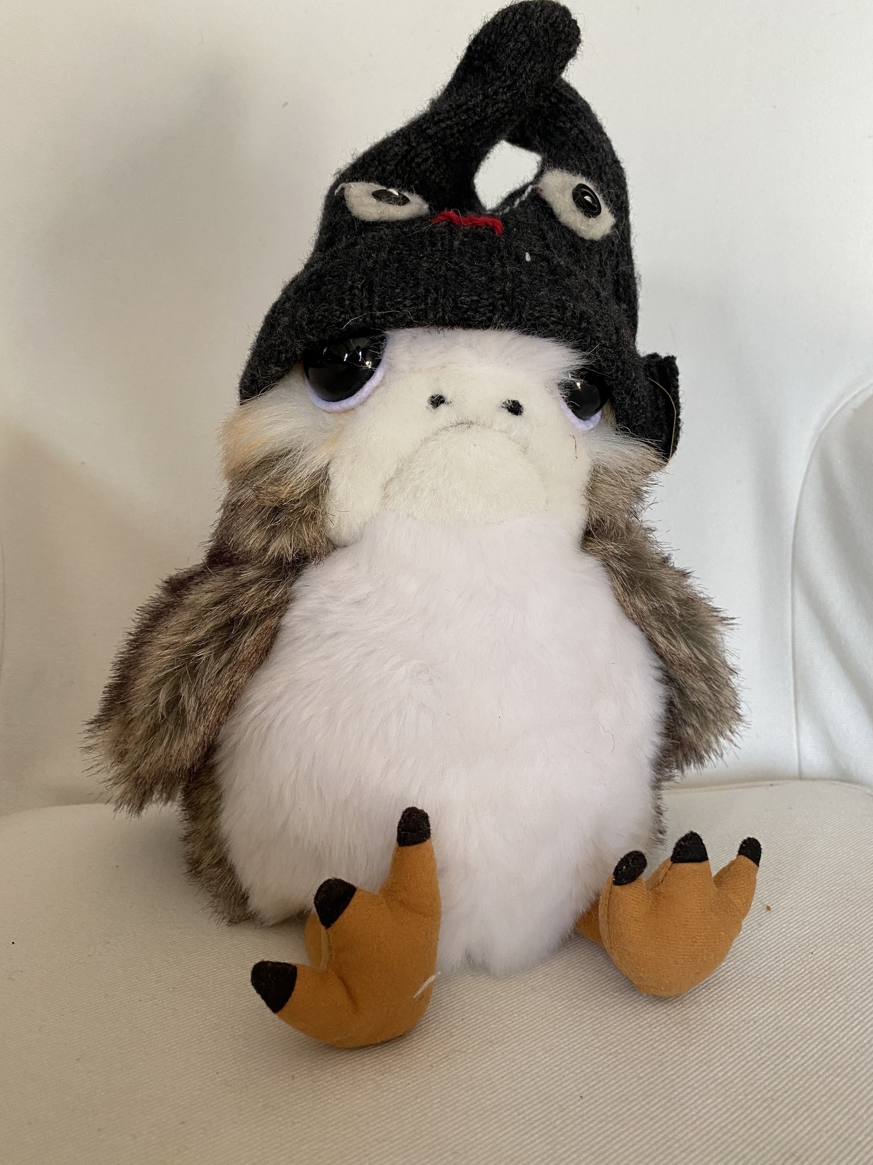Close up of a porg wearing a stocking cap with eyes.