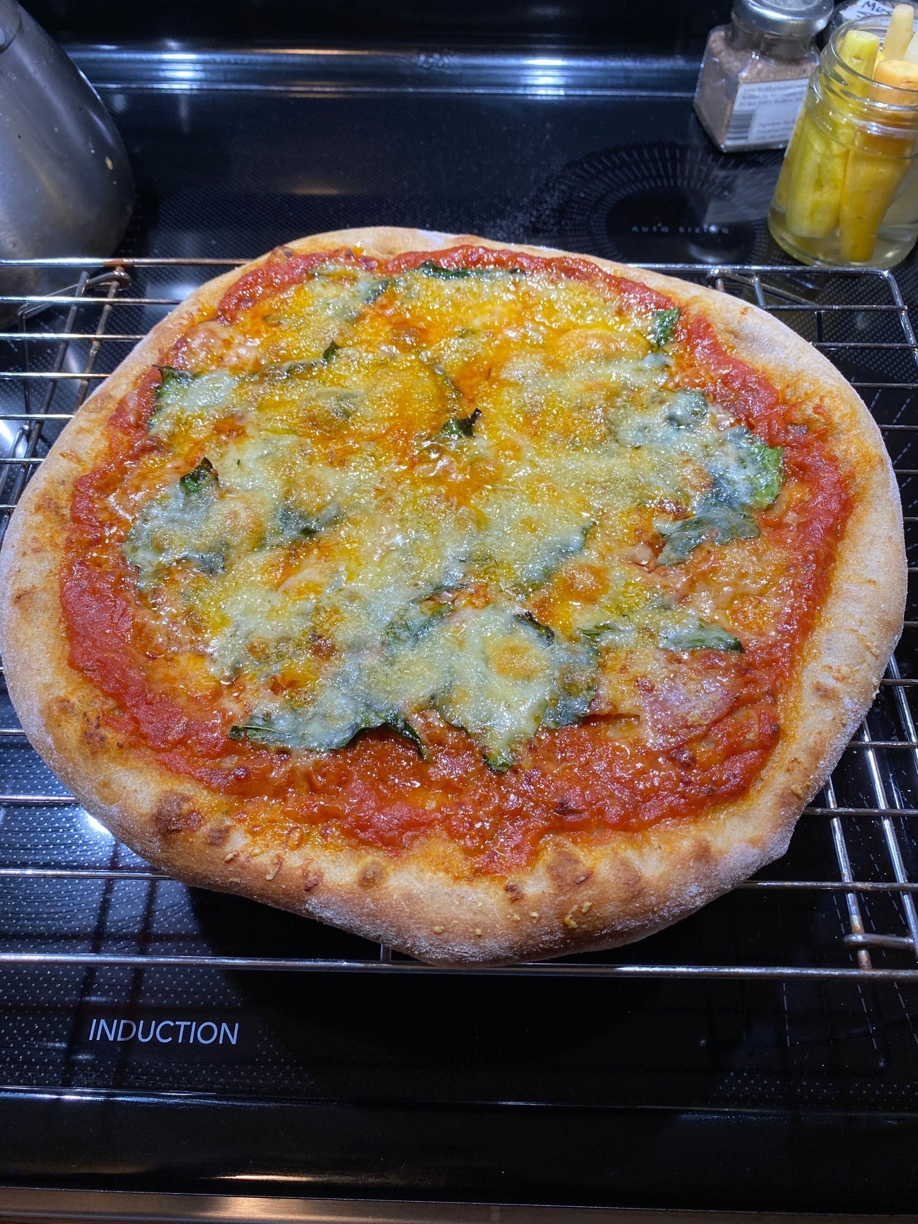 Small pizza on a cooling rack.