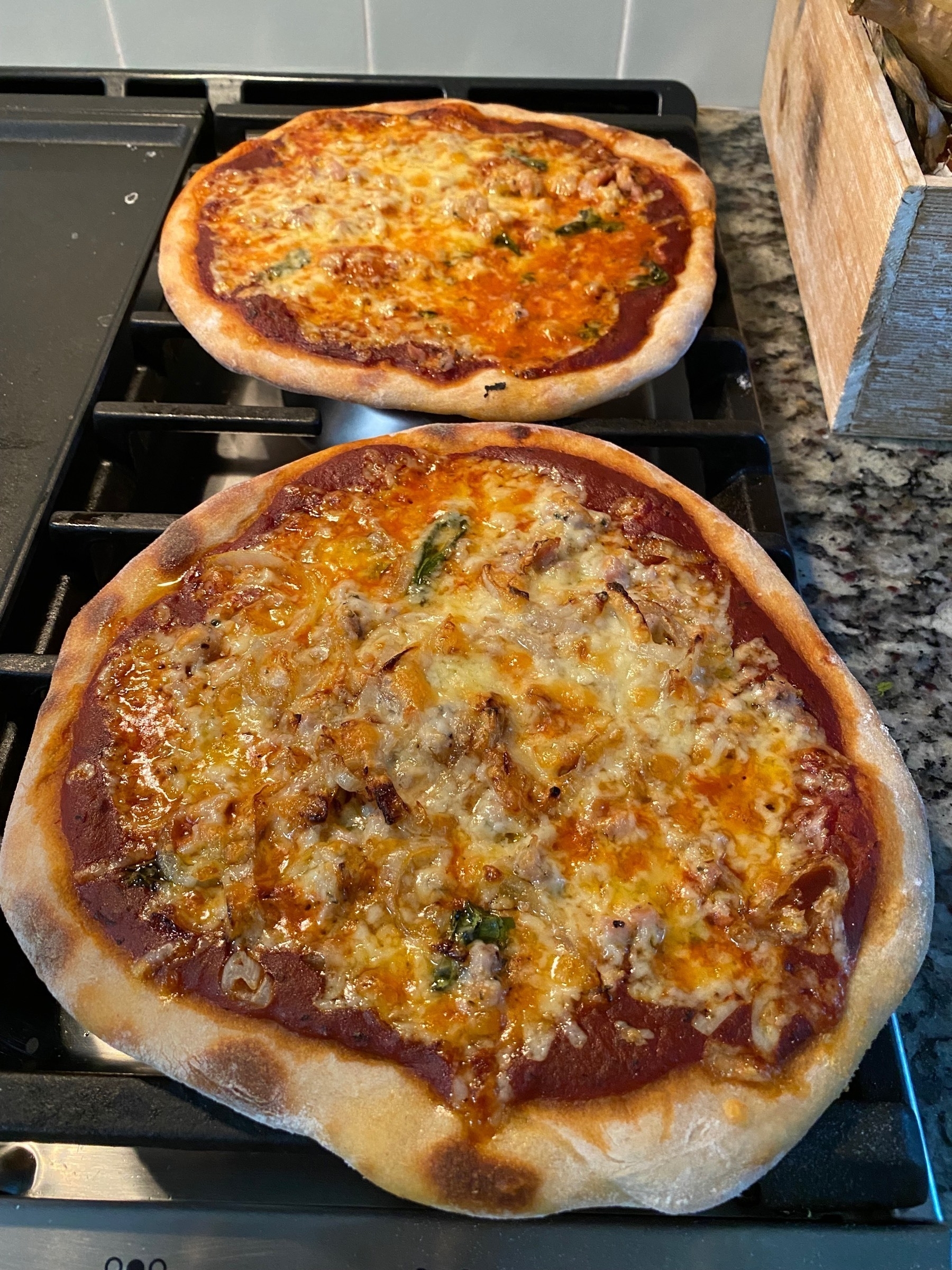 Two small pizzas on a stove top.