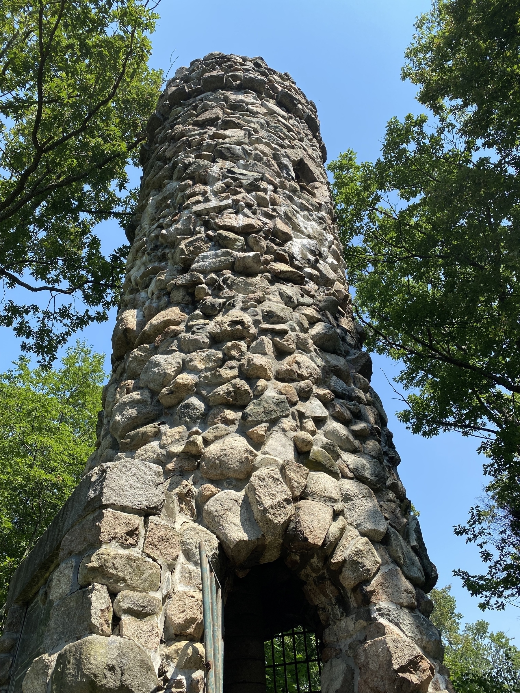 View of a stone tower with trees on either side.