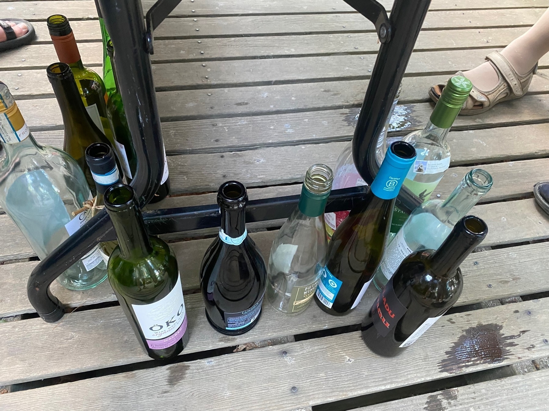Empty wine bottles on a wooden porch.