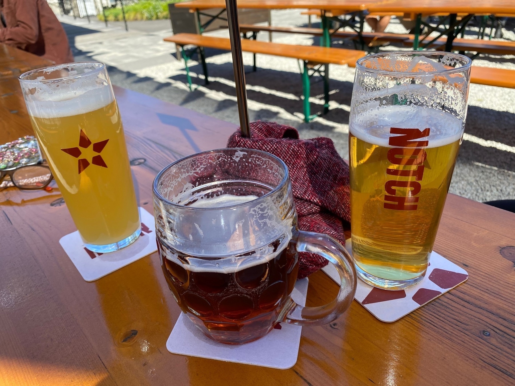 Three glasses of beer sitting on a table.