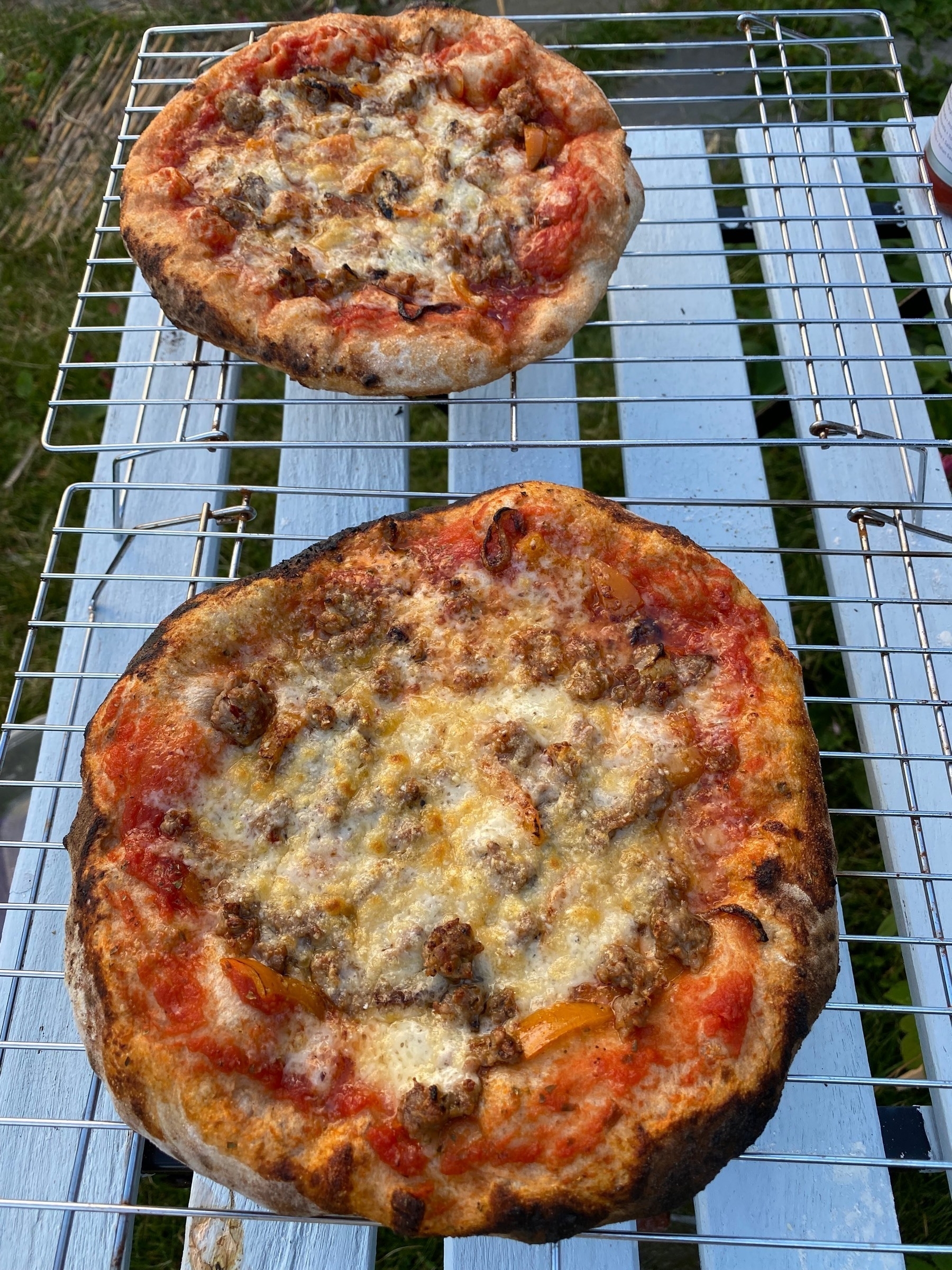 Two small pizzas on cooling racks.