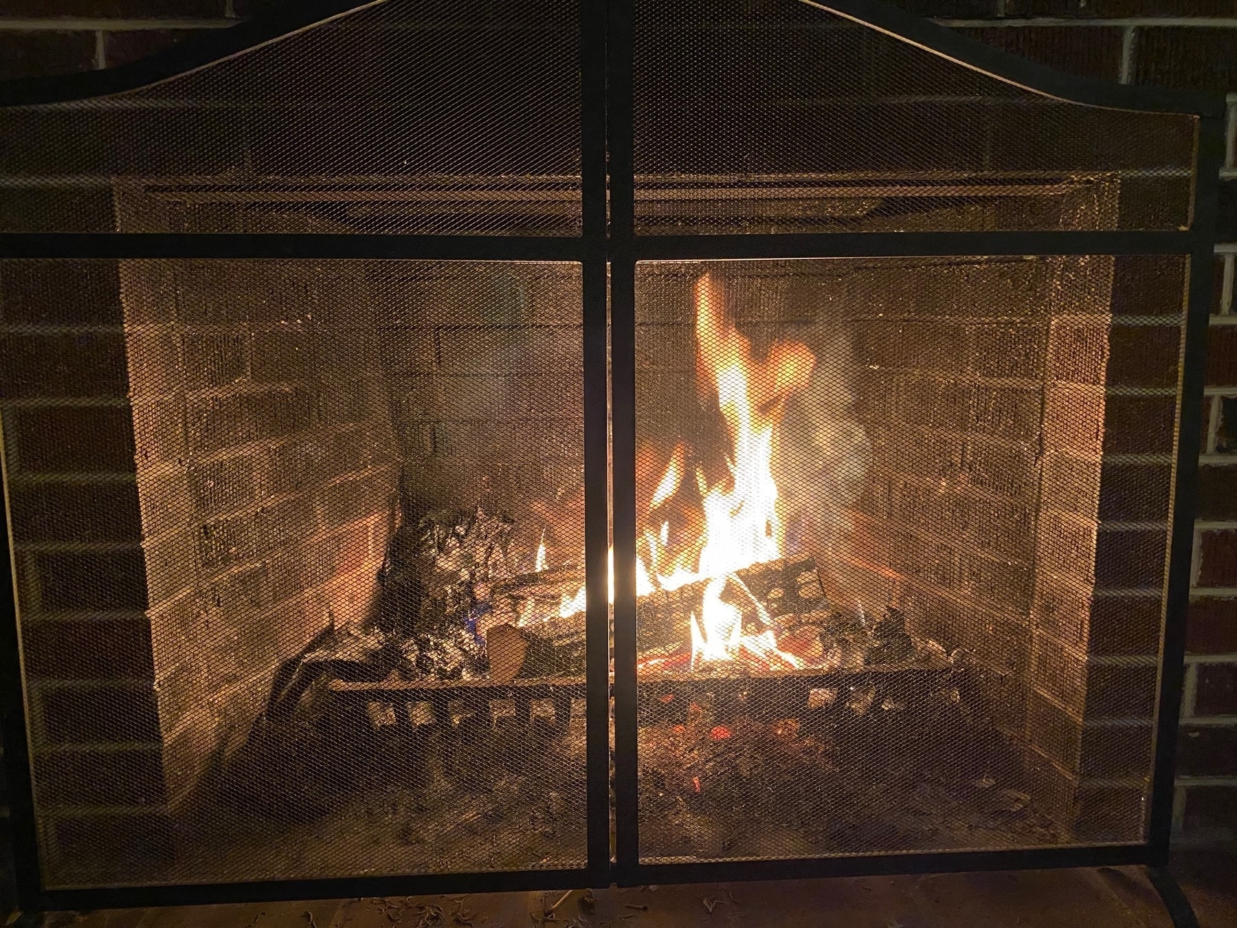A wood fire burning in a small fireplace.