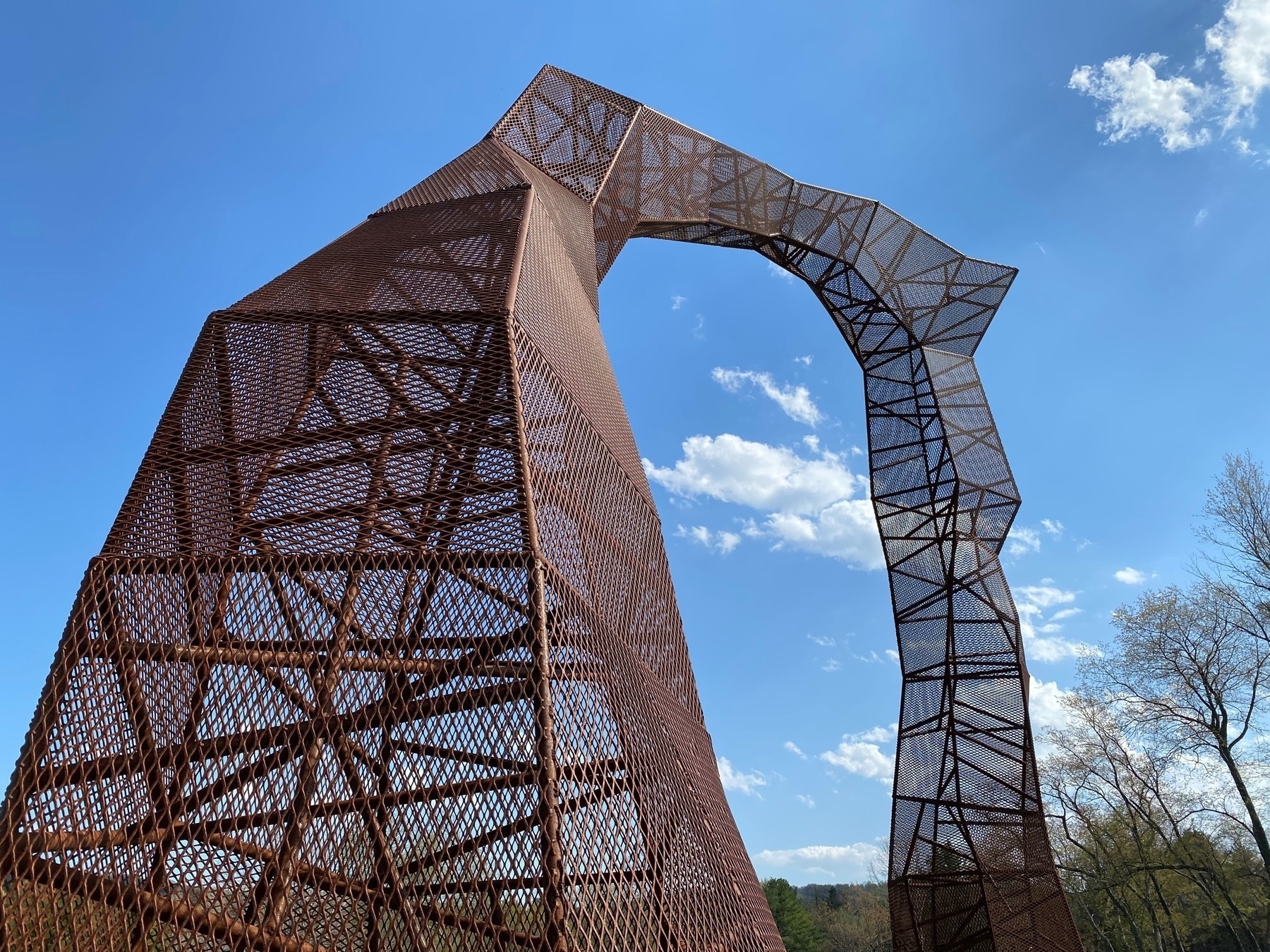 A metal latticework sculpture against a blue sky.
