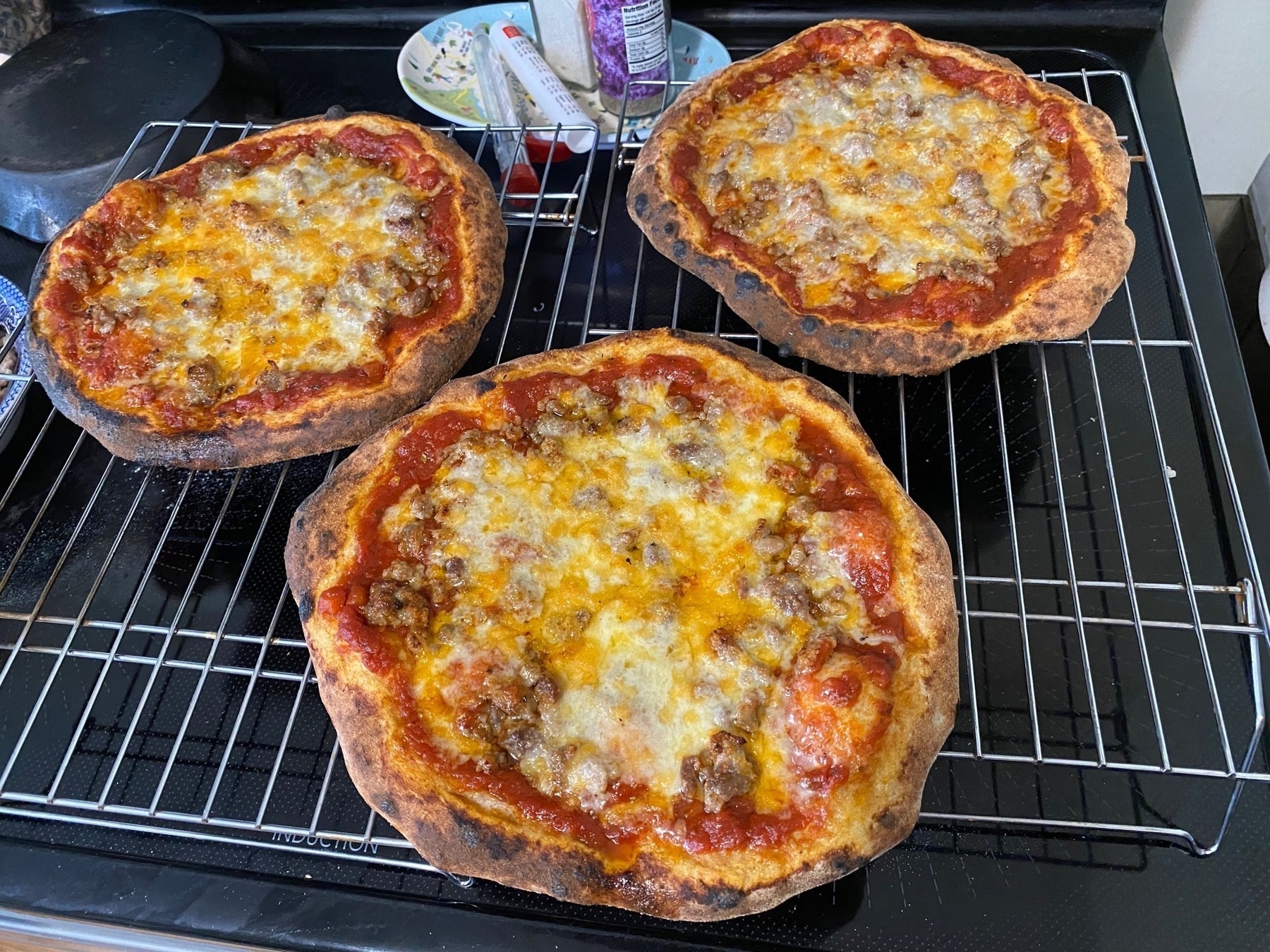 Three small pizzas on cooling racks.