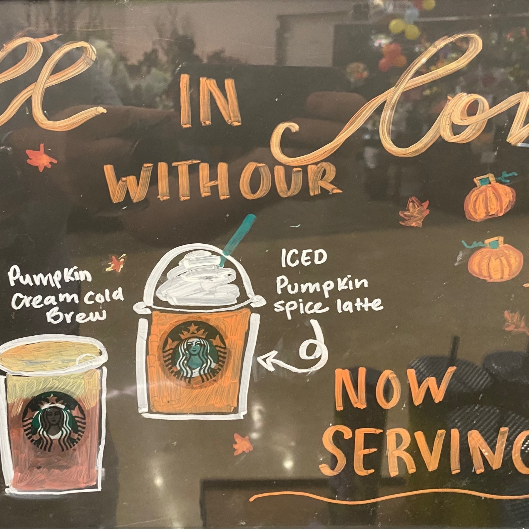 Hand lettered sign at Starbucks for pumpkin spice drinks.