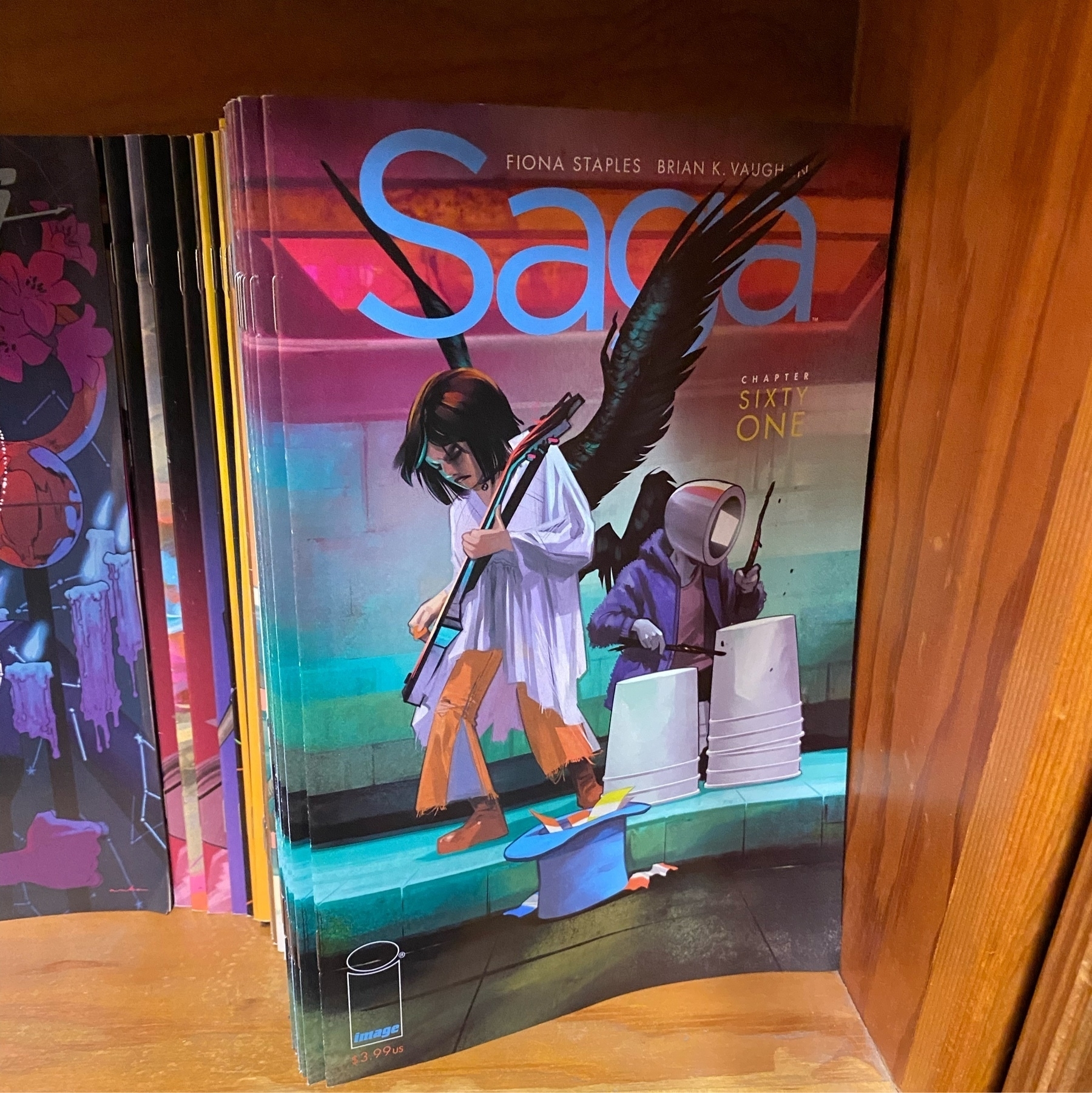 Stack of Saga #61 comic books on a shelf.