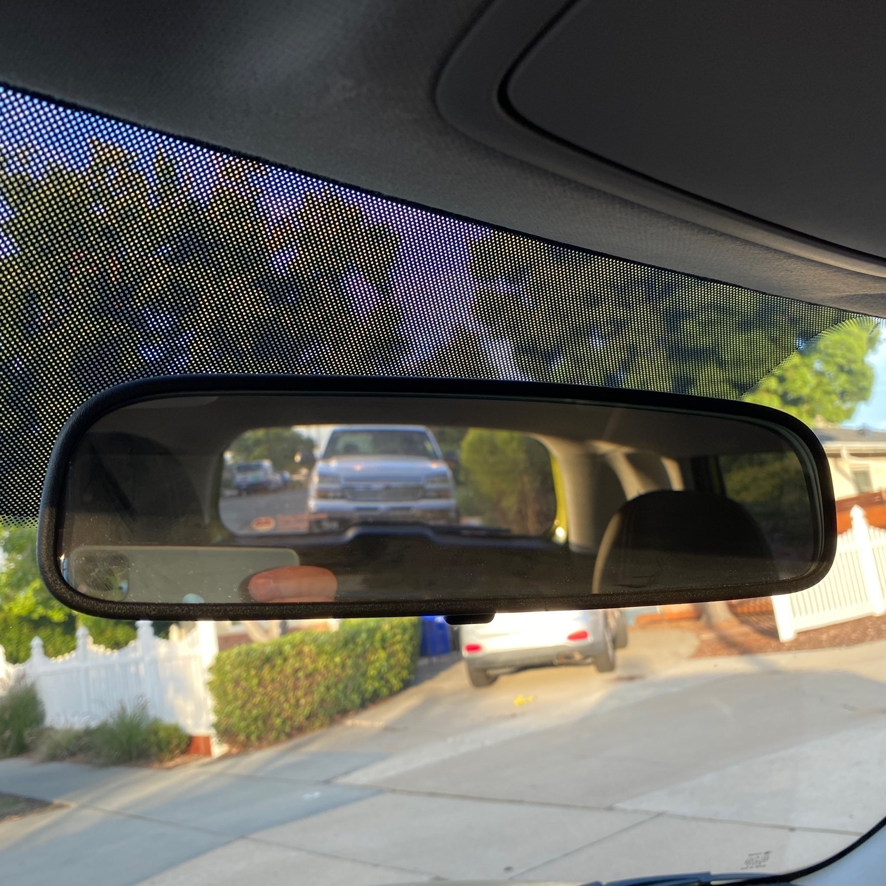 Close up of a car's rear-view mirror showing a truck behind the car.